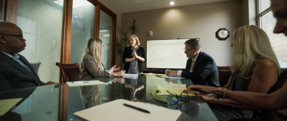 Mary E. Lentz talking to a group of individuals in a conference room