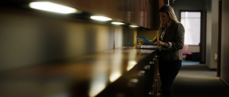 Cassandra Andres Rice reading documents at the counter